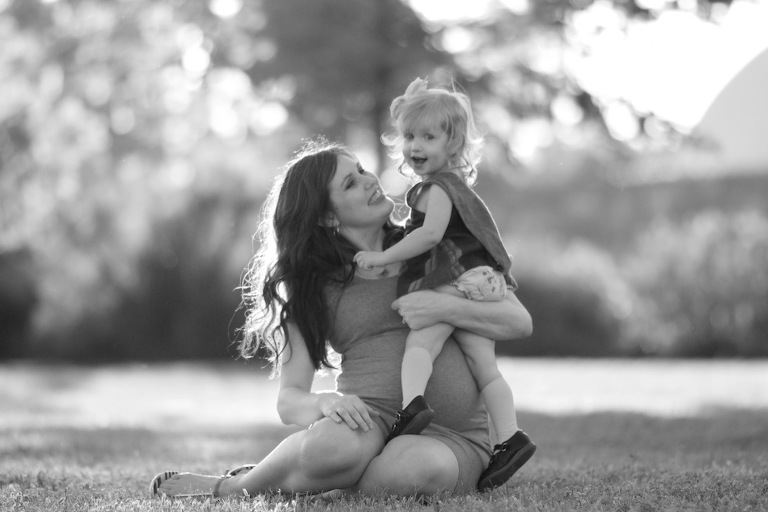 Pregnant mom holding daughter