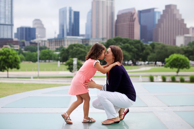 Mom kissing daughter