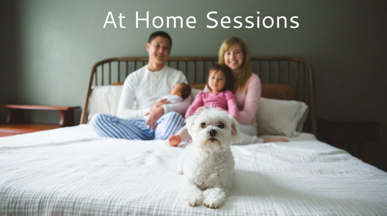 New family of 4 sitting on bed with dog
